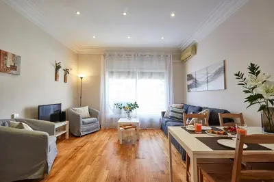 a living room with a couch and a table at BBarcelona Gaudí Avenue Flat in Barcelona