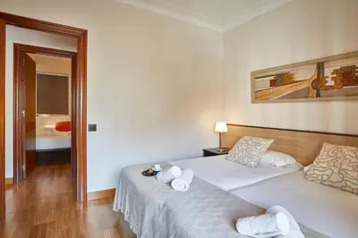 a hotel room with two beds with towels on them at BBarcelona Gaudí Avenue Flat in Barcelona