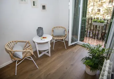 a balcony with two chairs and a table on a porch at Mai & Maud Ronda Apartment in Barcelona