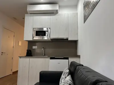 a living room with a couch and a microwave at Apartahotel Baldiri in Sant Boi del Llobregat