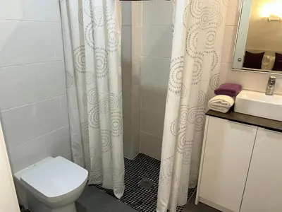 a bathroom with a white shower curtain and a toilet at Apartahotel Baldiri in Sant Boi del Llobregat