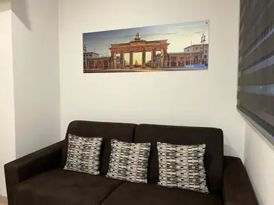 a couch in a room with a picture on the wall at Apartahotel Baldiri in Sant Boi del Llobregat