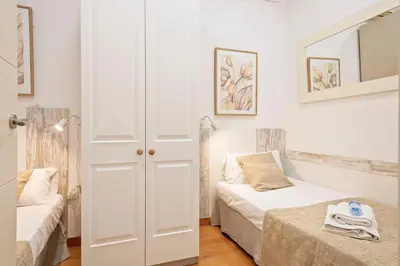 a white room with a bed and a couch at Alcam Paseo San Juan in Barcelona