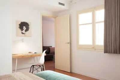 a bedroom with a desk and a window at Click&Flat Europa Fira Apartments in Hospitalet de Llobregat