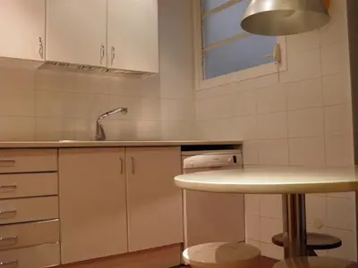 a kitchen with white cabinets and a sink at Suitur Courtyard Apartment in Barcelona