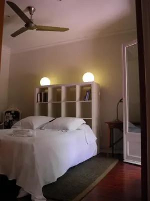 a bedroom with a large white bed with shelves at Suitur Courtyard Apartment in Barcelona