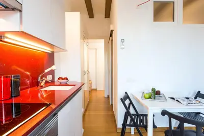 a kitchen with a red counter top and a table at Casa Cosi Sant Antoni in Barcelona