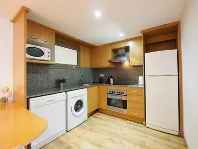 a kitchen with a white refrigerator and a dishwasher at Paseo de Gracia Design in Barcelona