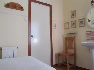 a bedroom with a bed and a sink and a mirror at Pension Alamar in Barcelona