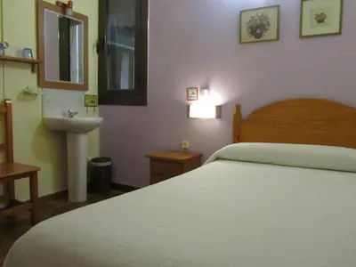a bedroom with a white bed and a sink at Pension Alamar in Barcelona