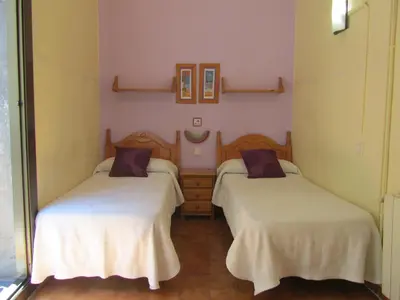 two beds in a room with white sheets at Pension Alamar in Barcelona