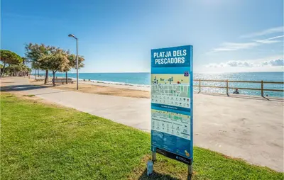 a sign in the grass next to a beach at Gorgeous Apartment In Pineda De Mar in Pineda de Mar