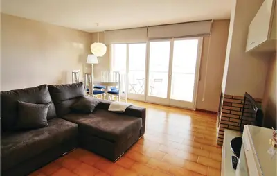 a living room with a brown couch and a table at Gorgeous Apartment In Pineda De Mar in Pineda de Mar