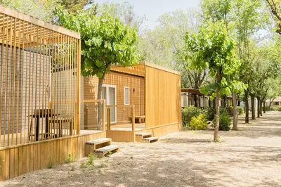 a couple of buildings with benches in front of them at Camping Sènia Caballo de Mar in Pineda de Mar