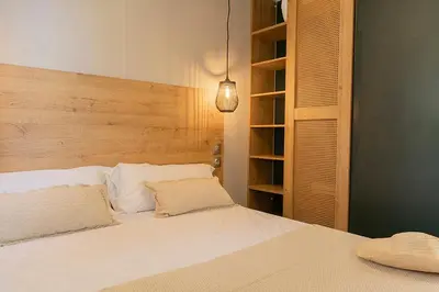 a bedroom with a white bed with a wooden headboard at Camping Sènia Caballo de Mar in Pineda de Mar