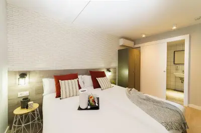 a bedroom with a large white bed with red pillows at BYPILLOW Wander in Barcelona