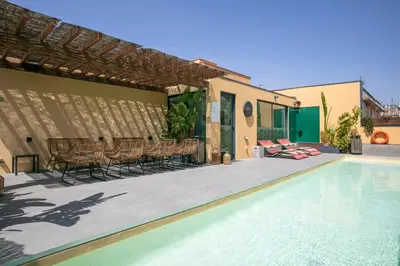 a swimming pool with chairs and a table next to a house at Niu Barcelona Hotel in Barcelona
