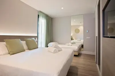 a hotel room with two beds and a television at Niu Barcelona Hotel in Barcelona