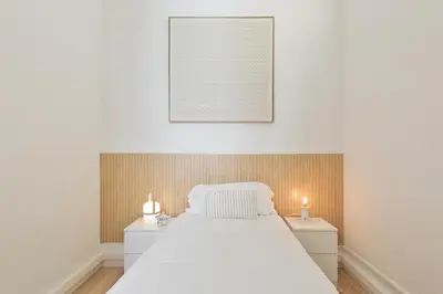 a bedroom with a white bed and two night stands at Suites4days Gaudi Eixample in Barcelona