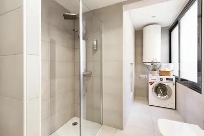 a bathroom with a shower and a washing machine at Modern Catalan Apartments by Olala Homes in Hospitalet de Llobregat
