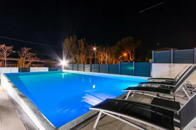 a swimming pool at night with lounge chairs at Luxurious Villa Marly I to two minutes the beach in Castelldefels