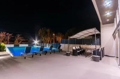 a patio with a table and chairs next to a swimming pool at Luxurious Villa Marly I to two minutes the beach in Castelldefels