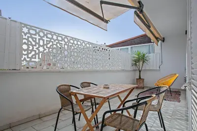 a patio with a wooden table and chairs at Destino Sitges in Sitges