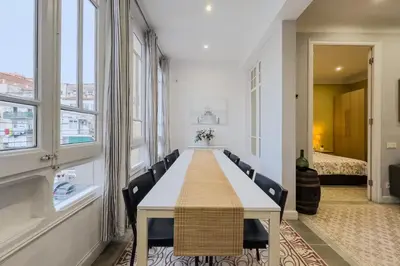 a long table in a large room with windows at Novus Homes Barcelona Eixample in Barcelona