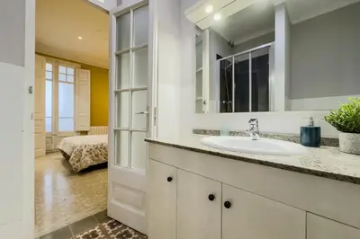 a bathroom with a sink and a mirror at Novus Homes Barcelona Eixample in Barcelona