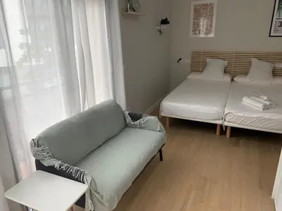 a living room with a couch and a bed and a window at Plaza de España independent house in Barcelona