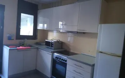 a kitchen with white cabinets and a microwave at Holidays Domus Iano in Esparreguera