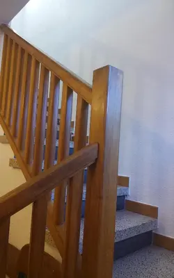 a wooden staircase with a wooden rail and a stair case at Holidays Domus Iano in Esparreguera