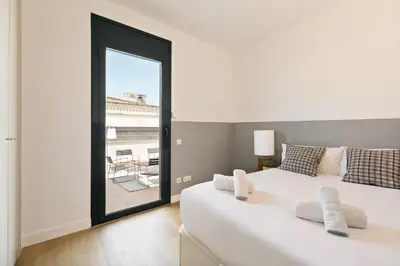 a bedroom with a large white bed and a large window at Ola Living Merce in Barcelona