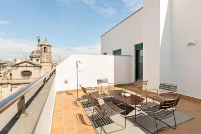 a balcony with a table and chairs on top of a building at Ola Living Merce in Barcelona