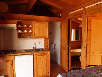 a kitchen with wooden cabinets and a sink at Camping El Pasqualet in Caldes de Montbui
