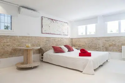 a bedroom with a bed with a red pillow on it at Studio Relax by Hello Homes Sitges in Sitges