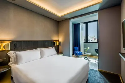 a bedroom with a large bed and a large window at Room Mate Collection Gerard, Barcelona in Barcelona