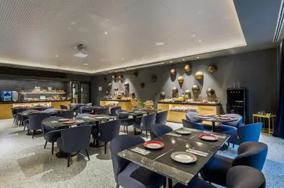 a restaurant with tables and chairs and a counter at Room Mate Collection Gerard, Barcelona in Barcelona