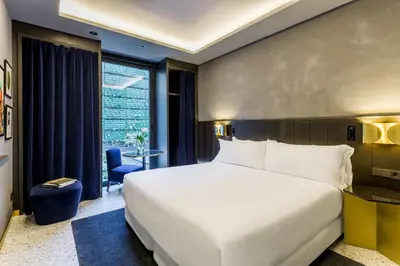a bedroom with a large white bed and a window at Room Mate Collection Gerard, Barcelona in Barcelona
