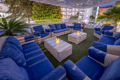 a patio with blue chairs and tables on a balcony at GHT Balmes, Hotel-Aparthotel&SPLASH in Calella