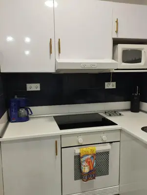 a kitchen with white cabinets and a stove top oven at Apartment Fira Bcn Camp Nou in Hospitalet de Llobregat