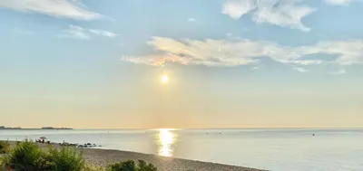 a view of a beach with the sun shining on the water at Musclera in Arenys de Mar