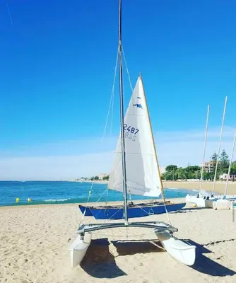 a sailboat sitting on the sand on a beach at Musclera in Arenys de Mar
