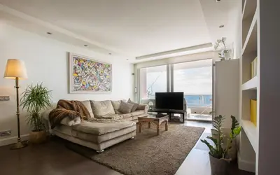 a living room with a couch and a television at Gava Beach 1st Line in Gavà