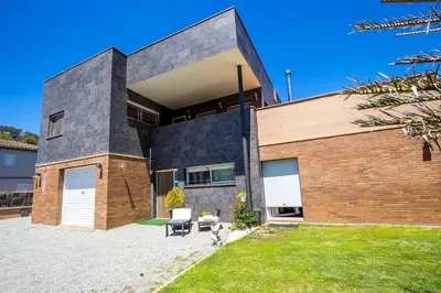 a dog is standing in front of a house at Catalunya Casas Modern and spacious with private pool close to BCN in Senmanat
