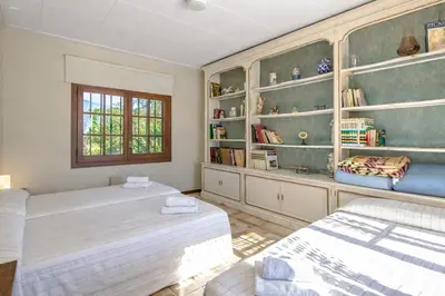 a bedroom with two beds and a book shelf at Catalunya Casas Nature and Tranquility for 24 pax - 30km to beach in Sant Pere de Vilamajor