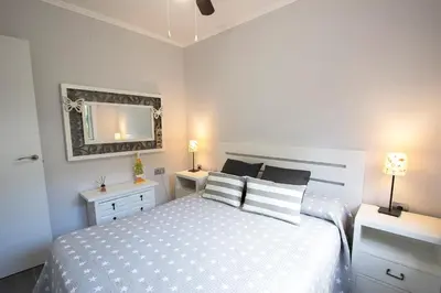 a bedroom with a white bed and a mirror at Catalunya Casas Mountain escape with amazing views just 25km to BCN! in Torrelles de Llobregat