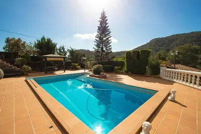 a large swimming pool in a yard with a house at Catalunya Casas Mountain escape with amazing views just 25km to BCN! in Torrelles de Llobregat
