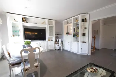 a living room with white cabinets and a flat screen tv at Catalunya Casas Mountain escape with amazing views just 25km to BCN! in Torrelles de Llobregat