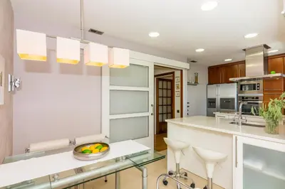 a kitchen with white cabinets and a bowl of fruit on a counter at HomeHolidaysRentals Amaral in Pineda de Mar